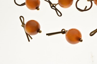 Lot 82 - Collection of thirteen amber bead buttons