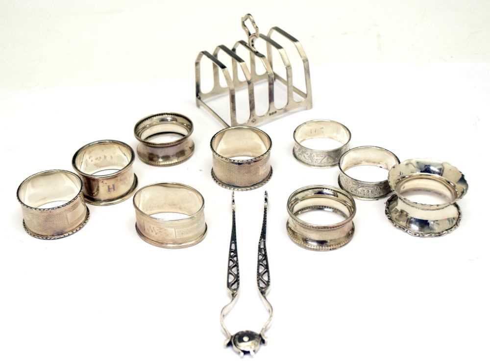 Lot 131 - Group of assorted silver napkin rings, a pair of Georgian sugar tongs and a George VI toast rack