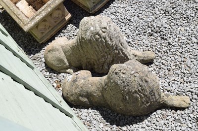 Lot 827 - Pair of composite stone garden lions in recumbent posture