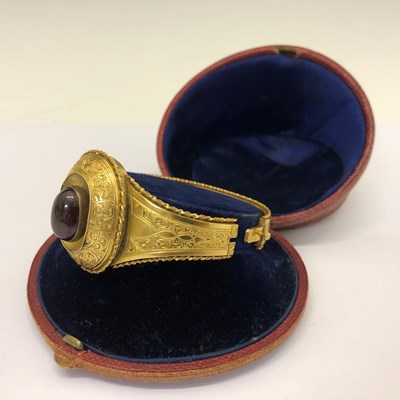 Lot 22 - A Victorian garnet set gold hinged bangle