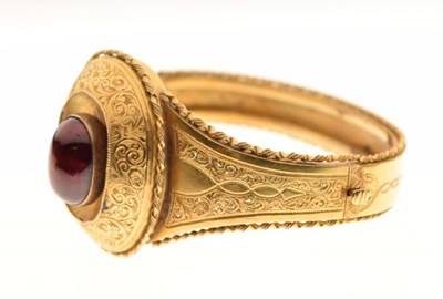 Lot 22 - A Victorian garnet set gold hinged bangle