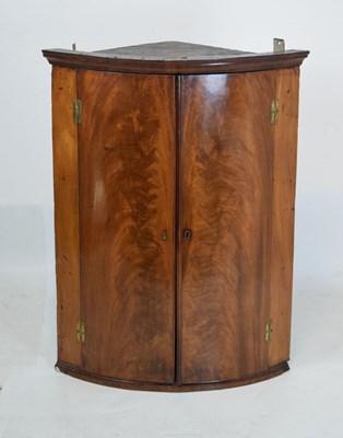 Lot 675 - George III mahogany bowfront corner cabinet