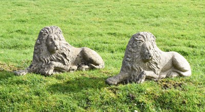 Lot 684 - Pair of composite stone garden lions in recumbent posture