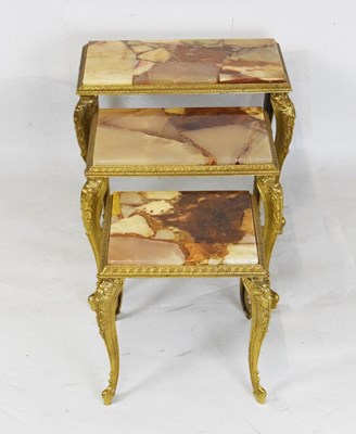 Lot 746 - Nest of three brass and onyx tables