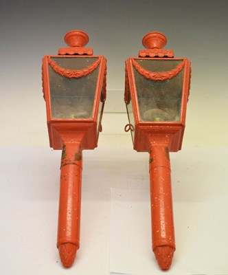 Lot 613 - Pair of red painted brass coach lamps and brackets