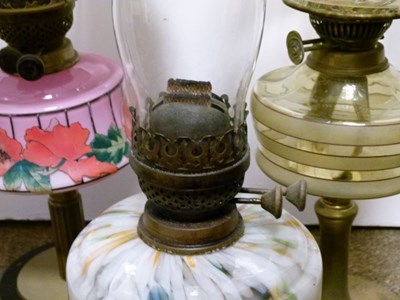 Lot 752 - Group of three early 20th century cast metal and glass oil lamps