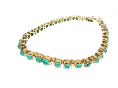 Lot 54 - Yellow metal, emerald and diamond 'tennis' bracelet