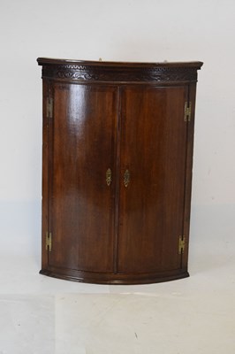 Lot 664 - George III oak and mahogany bowfront corner cupboard