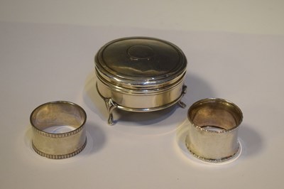 Lot 247 - George V silver circular lidded dressing table box, plus two silver napkin rings