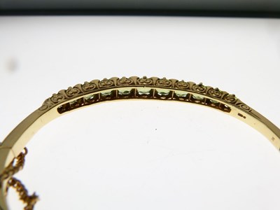 Lot 13 - Edwardian style 14ct gold peridot and diamond hinged bangle