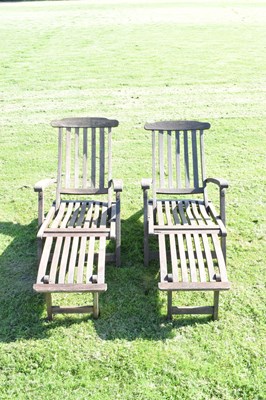 Lot 670 - Pair of teak reclining steamer chairs