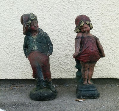 Lot 653 - Painted composite stone figures of a boy and girl