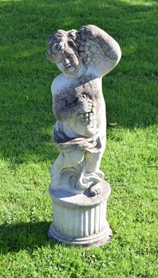 Lot 649 - Composite stone garden statue of a cherub holding grapes