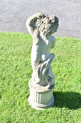 Lot 726 - Composite stone garden statue of a cherub holding grapes