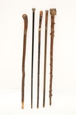Lot 320 - Edwardian silver capped walking cane, together with four walking sticks