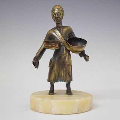 Lot 545 - Eastern alloy figure of a street seller