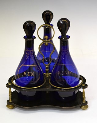 Lot 383 - Early 19th century set of three blue glass decanters and stand