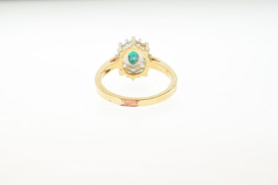 Lot 3 - Dress ring set green oval cut centre stone within a border of white stones