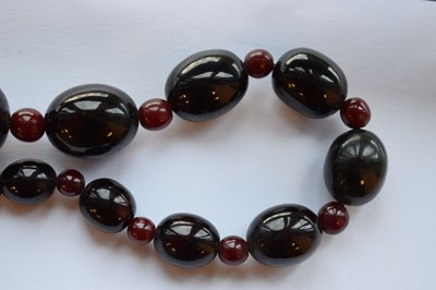 Lot 51 - 'Cherry amber' coloured bead necklace