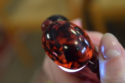 Lot 51 - 'Cherry amber' coloured bead necklace