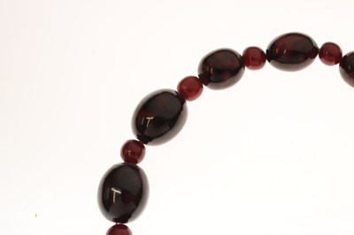 Lot 51 - 'Cherry amber' coloured bead necklace