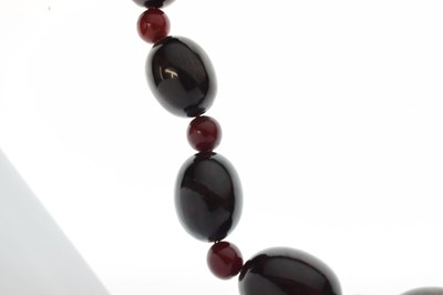 Lot 51 - 'Cherry amber' coloured bead necklace