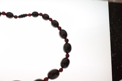 Lot 51 - 'Cherry amber' coloured bead necklace