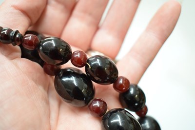 Lot 51 - 'Cherry amber' coloured bead necklace