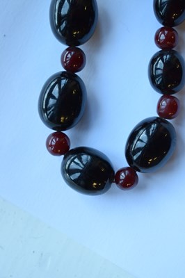 Lot 51 - 'Cherry amber' coloured bead necklace