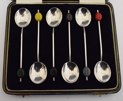 Lot 144 - Cased set of six George V silver demi-tasse coffee spoons with coloured 'bean' terminals