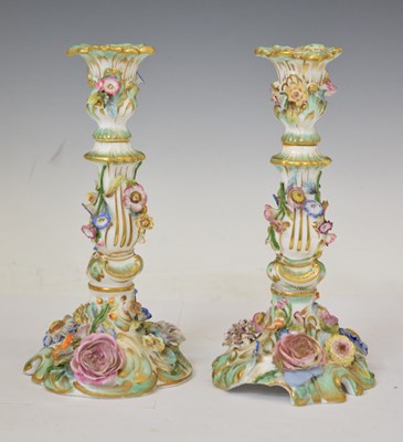 Lot 438 - Pair of early 20th century Continental flower-encrusted candlesticks