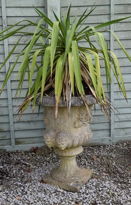 Lot 712 - Composition stone garden pedestal urn with mask and foliate decoration