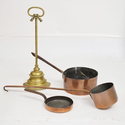 Lot 749 - Gilt metal doorstop and three copper pans