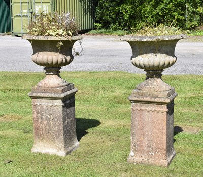 Lot 790 - Pair of composition stone garden urns and pedestals