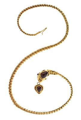 Lot 47 - Victorian garnet set yellow metal serpent pendant necklace, the textured snake head set with garnet carbuncle