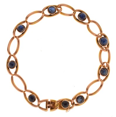 Lot 57 - Gold bracelet, the oval links alternate set sapphire cabochons