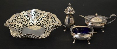 Lot 211 - Elizabeth II silver pierced bonbon dish and a three-piece condiment set