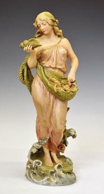 Lot 522 - Royal Dux - Porcelain figure of a fisherwoman holding net and shell