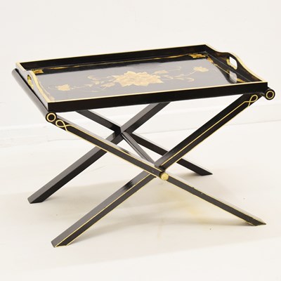 Lot 724 - Black lacquered tray table and stand with gold floral decoration