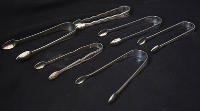 Lot 252 - Six pairs of George III silver sugar tongs each with bright-cut decoration