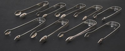 Lot 253 - Nine pairs of George III silver sugar tongs, eight with bright-cut decoration