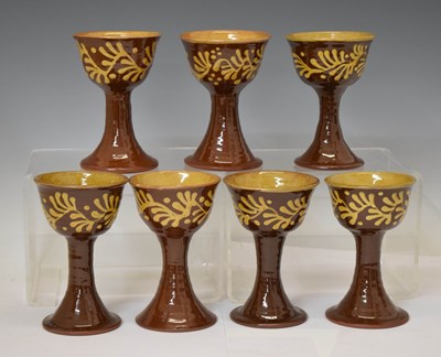 Lot 538 - Studio Pottery - Set of eight slip decorated terracotta goblets by Wetheriggs Pottery