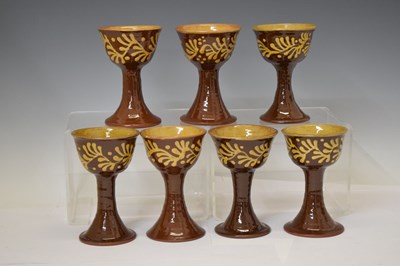 Lot 538 - Studio Pottery - Set of eight slip decorated terracotta goblets by Wetheriggs Pottery