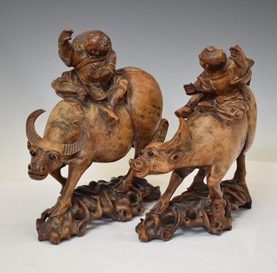 Lot 558 - Pair of Chinese carved hardwood figures of boys riding buffalo