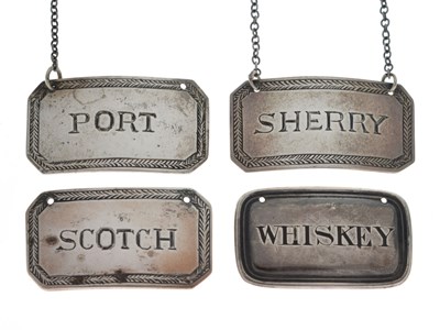 Lot Set of three white-metal decanter labels and a Victorian silver 'Whiskey' label