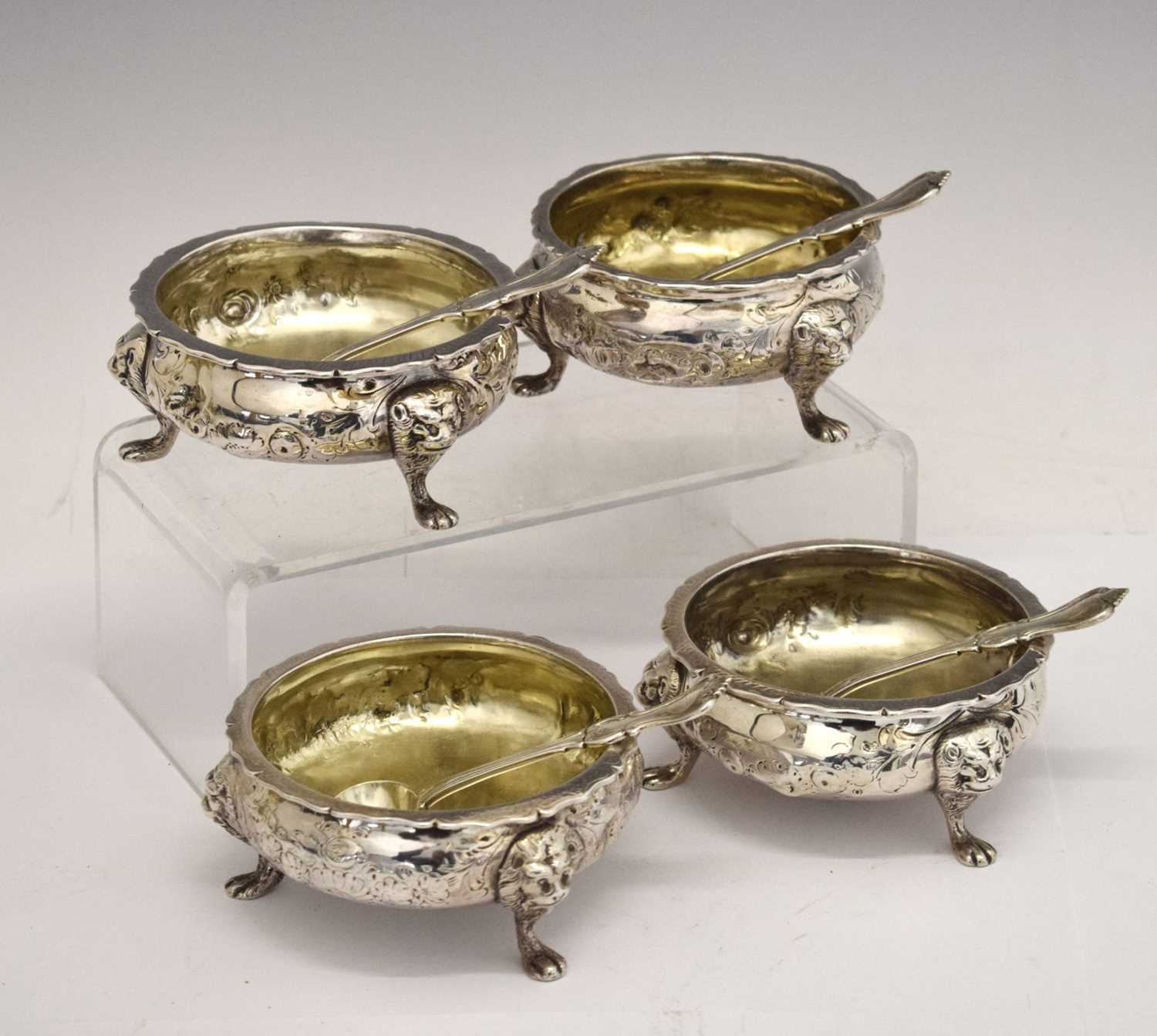 Lot 112 - Matched set of four silver salts each standing on three mask and paw feet