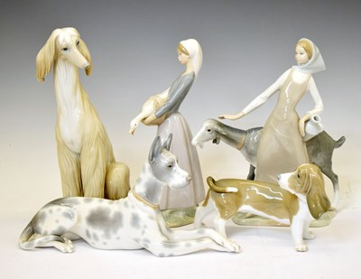 Lot 529 - Lladro - Two porcelain figure groups of farming maids and three dogs