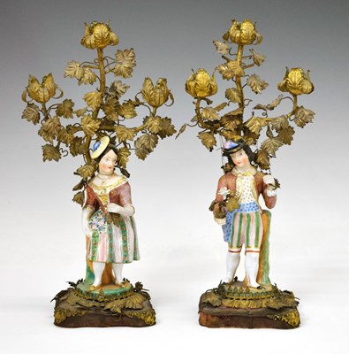 Lot 234 - Pair of late 19th century Continental gilt metal and porcelain mounted figural candlesticks