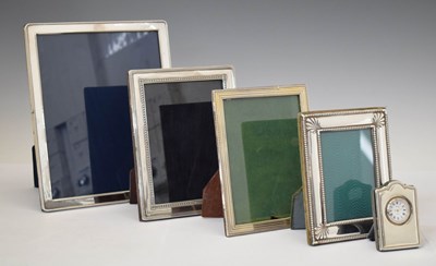 Lot 278 - Four Elizabeth II silver mounted easel photo frames and desk clock