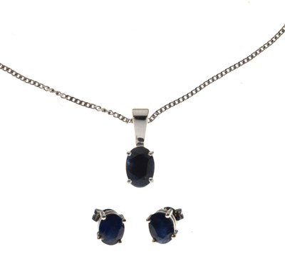 Lot 136 - 9ct white gold and sapphire pendant and a pair of matching earrings